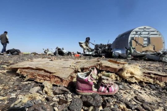
Một chiếc giày trẻ em nằm trên những mảnh vỡ của chiếc Airbus A321 xấu số. Ảnh: Reuters
