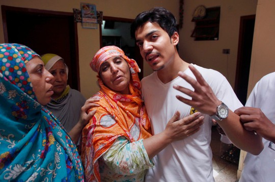 Hasan Khan (giữa) được gia đình an ủi sau khi vợ anh bị chính mẹ đẻ thiêu sống. Ảnh: AP