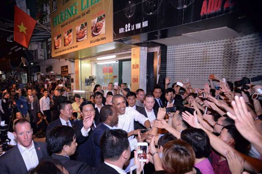 Tổng thống Mỹ Barack Obama bắt tay người dân sau khi ăn tối tại một quán bún chả ở Hà Nội tối 23-5. Ảnh: EPA