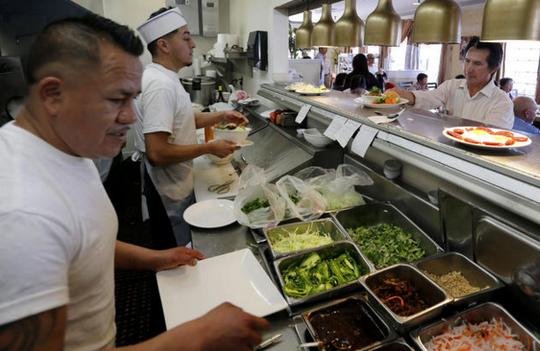
Roberto Torres chuẩn bị bữa ăn theo yêu cầu của khách trong khu bếp của nhà hàng Song Long. Ảnh: Los Angeles Times
