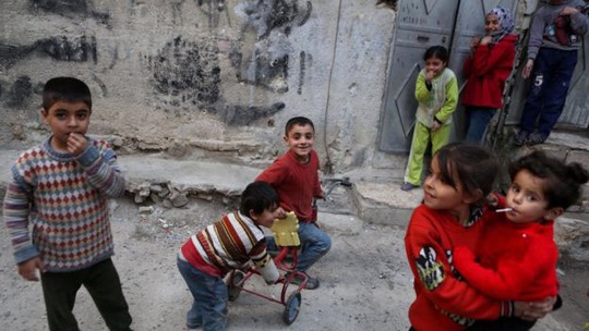 Trẻ em chơi đùa ở quận Tishreen, khu vực quân nổi dậy kiểm soát thuộc thủ đô Damascus - Syria, khi lệnh ngừng bắn có hiệu lựcẢnh: EPA