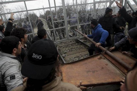 Những người di cư cố phá hàng rào ở biên giới Macedonia và Hy Lạp Ảnh: Reuters