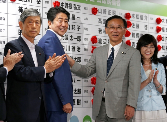 
Thủ tướng Shinzo Abe cài hoa vào tên ứng viên được kỳ vọng giành được ghế ở Thượng viện tại trụ sở LDP

Ảnh: REUTERS
