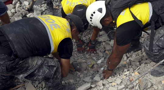 Lực lượng cứu hộ tìm thấy thi thể một nạn nhân tại khu dân cư Tarqui, TP Manta – Ecuador hôm 17-4 Ảnh: Reuters