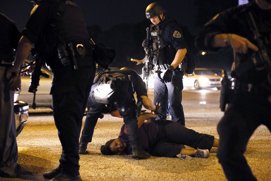 Cảnh sát bắt giữ một phụ nữ biểu tình gần trụ sở cảnh sát TP Baton Rouge, bang Louisiana đêm 9-7 Ảnh: REUTERS