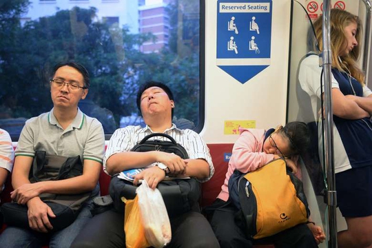 Người dân Singapore tranh thủ chợp mắt trên chuyến tàu điện vào buổi sáng Ảnh: The Straits Times