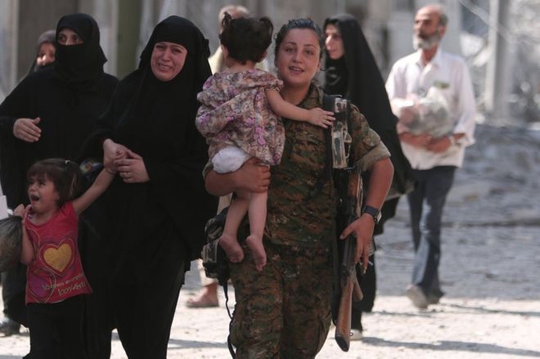 Thành viên SDF dẫn người dân tới nơi an toàn trong chiến dịch tái chiếm Manbij Ảnh: REUTERS