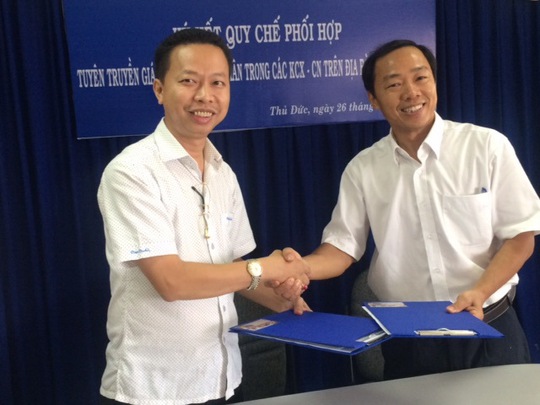 Ông Nguyễn Thành Đô (bìa trái), Chủ tịch Công đoàn các KCX-KCN TP và đại diện Công ty Điện lực Thủ Đức trao đổi văn bản ký kết