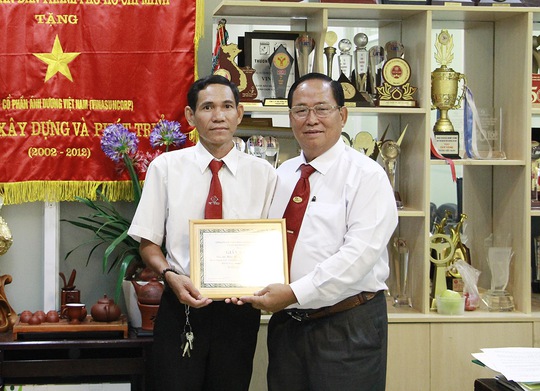 Leg: Ông Tạ Long Hỷ (bìa phải), Phó tổng giám đốc Vinasun, trao giấy khen và tiền thưởng cho tài xế Bình