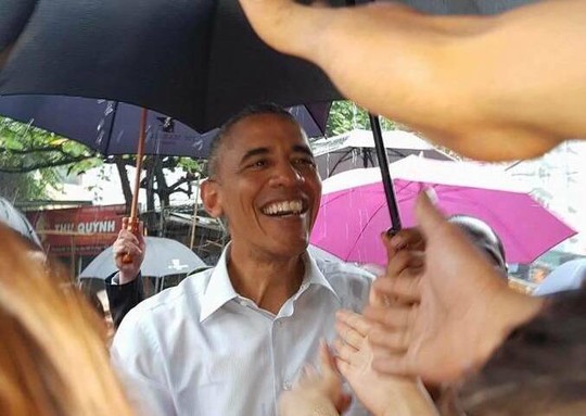 Tổng thống Obama nở nụ cười tươi thân thiện trò chuyện với người dân dưới trời mưa to - Ảnh: Nguyễn Hưởng