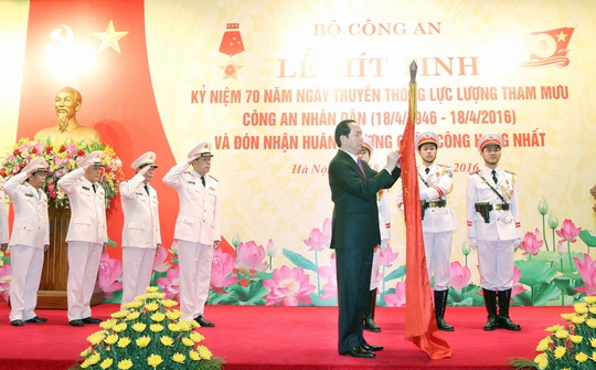 Chủ tịch nước Trần Đại Quang gắn Huân chương Quân công hạng nhất lên cờ truyền thống của Văn phòng Bộ Công an Ảnh: TTXVN