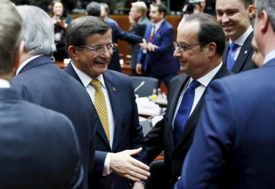 Thủ tướng Thổ Nhĩ Kỳ Ahmet Davutoglu (trái) bắt tay với Tổng thống Pháp Francois Hollande tại buổi họp ký kết thỏa thuận ở Brussels hôm 18-3. Ảnh: Reuters
