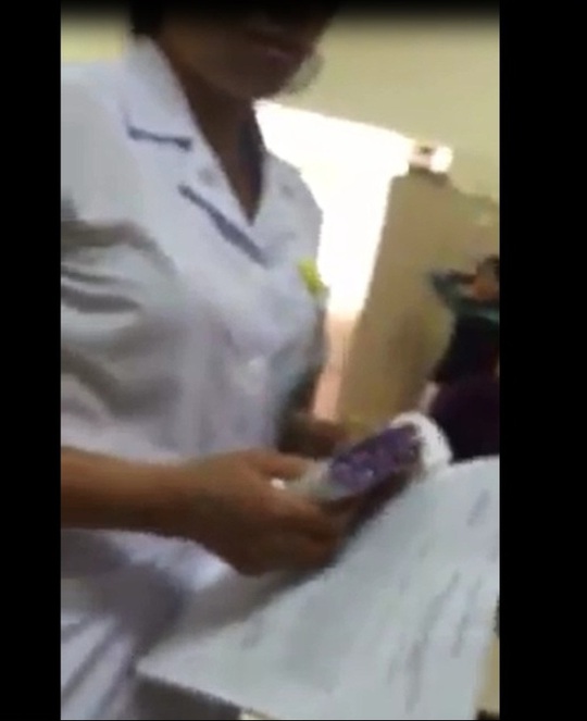 
Hình ảnh trong clip cho thấy nhân viên y tế này đang cầm cả tập phong bì được cho là nhận từ người nhà bệnh nhân

