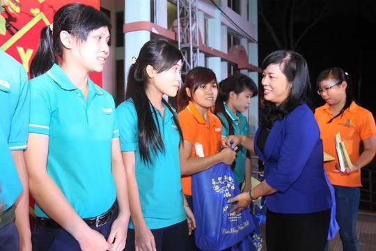 Bà Trần Kim Yến, Phó ban Dân vận Thành ủy, trao vé xe và quà Tết cho công nhân các KCX-KCN Ảnh: HOÀNG TRIỀU