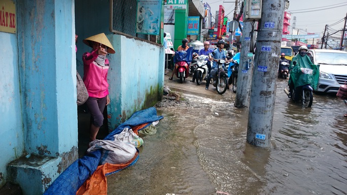 
Một gia đình phải lấy bạt che chắn để ngăn nước tràn vào nhà
