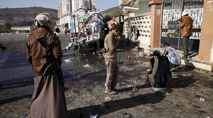 Một phiến quân Houthi đứng bên ngoài một ngôi đền ở thủ đô Sanaa của Yemen hôm 7-10. Ảnh: REUTERS