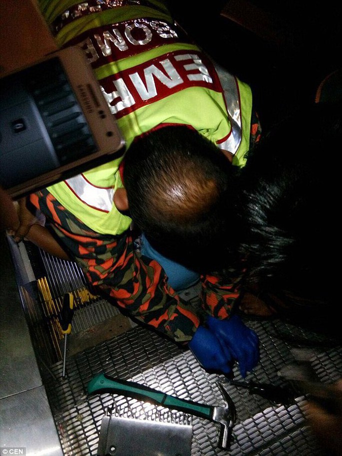
Lực lượng cứu hộ tháo thang cuốn để cứu cậu bé. Ảnh: CEN
