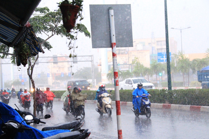 
Người chạy xe máy hối hả lưu thông trong cơn mưa lớn
