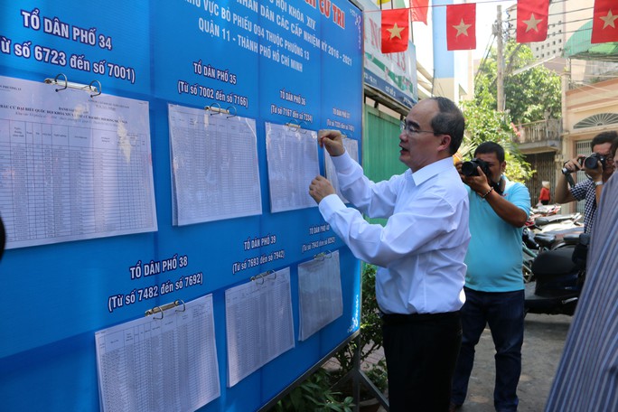 Ông Nguyễn Thiện Nhân kiểm tra một điểm niêm yết danh sách cử tri tại phường 13, quận 11, TP HCM vào sáng 23-4