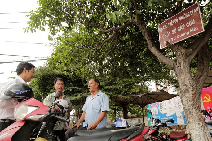 Lãnh đạo Hội Chữ thập đỏ phường Dĩ An (bìa trái) trao đổi với 2 thành viên “Đội xe máy cứu thương”