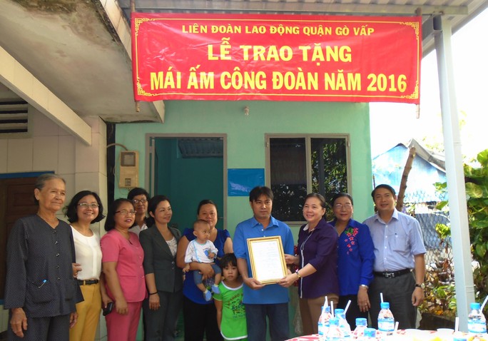 Vợ chồng anh Nguyễn Văn Lực vui mừng nhận quyết định tặng “Mái ấm Công đoàn” Ảnh: THI KIỀU