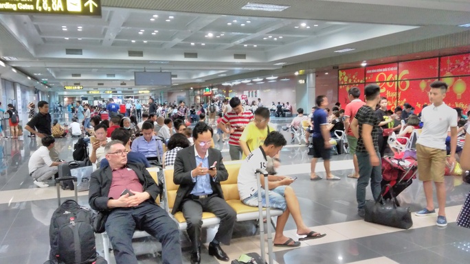 Hành khách chờ làm thủ tục tại sân bay Nội bài sau khi bị sự cố tấn công mạngẢnh: HẢI LINH