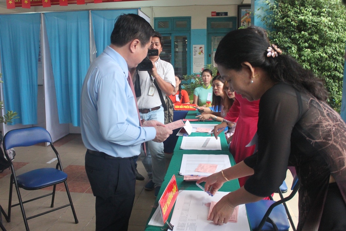 
Ông Nguyễn Thành Phong nhận phiếu từ tổ bầu cử để tiến hành bỏ phiếu.
