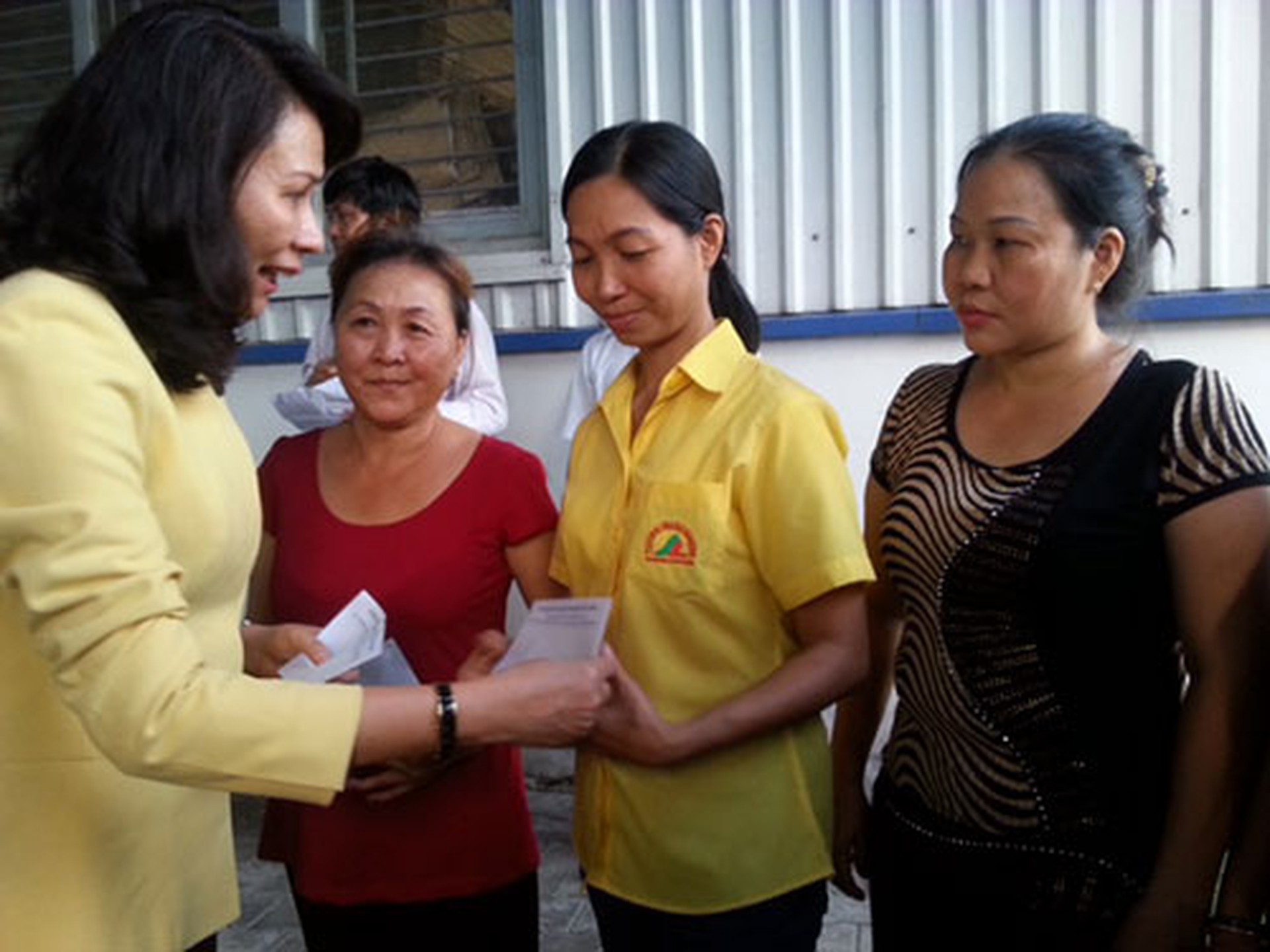 B&agrave; Nguyễn Thị Thu, Chủ tịch LĐLĐ TP HCM, trao tiền hỗ trợ cho c&ocirc;ng nh&acirc;n