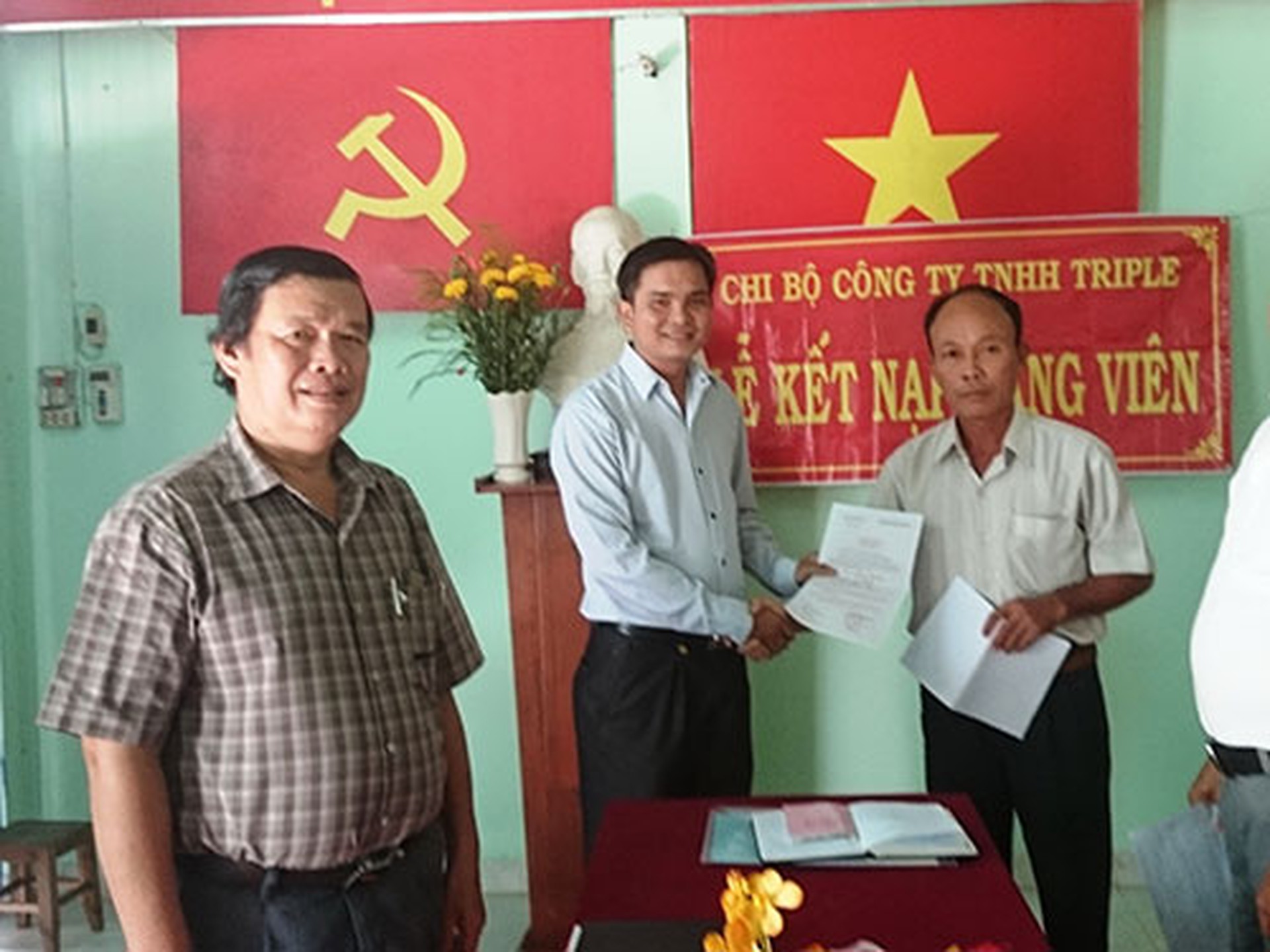 &Ocirc;ng L&ecirc; Trần Thanh Hải (giữa) nhận quyết định kết nạp đảng vi&ecirc;n