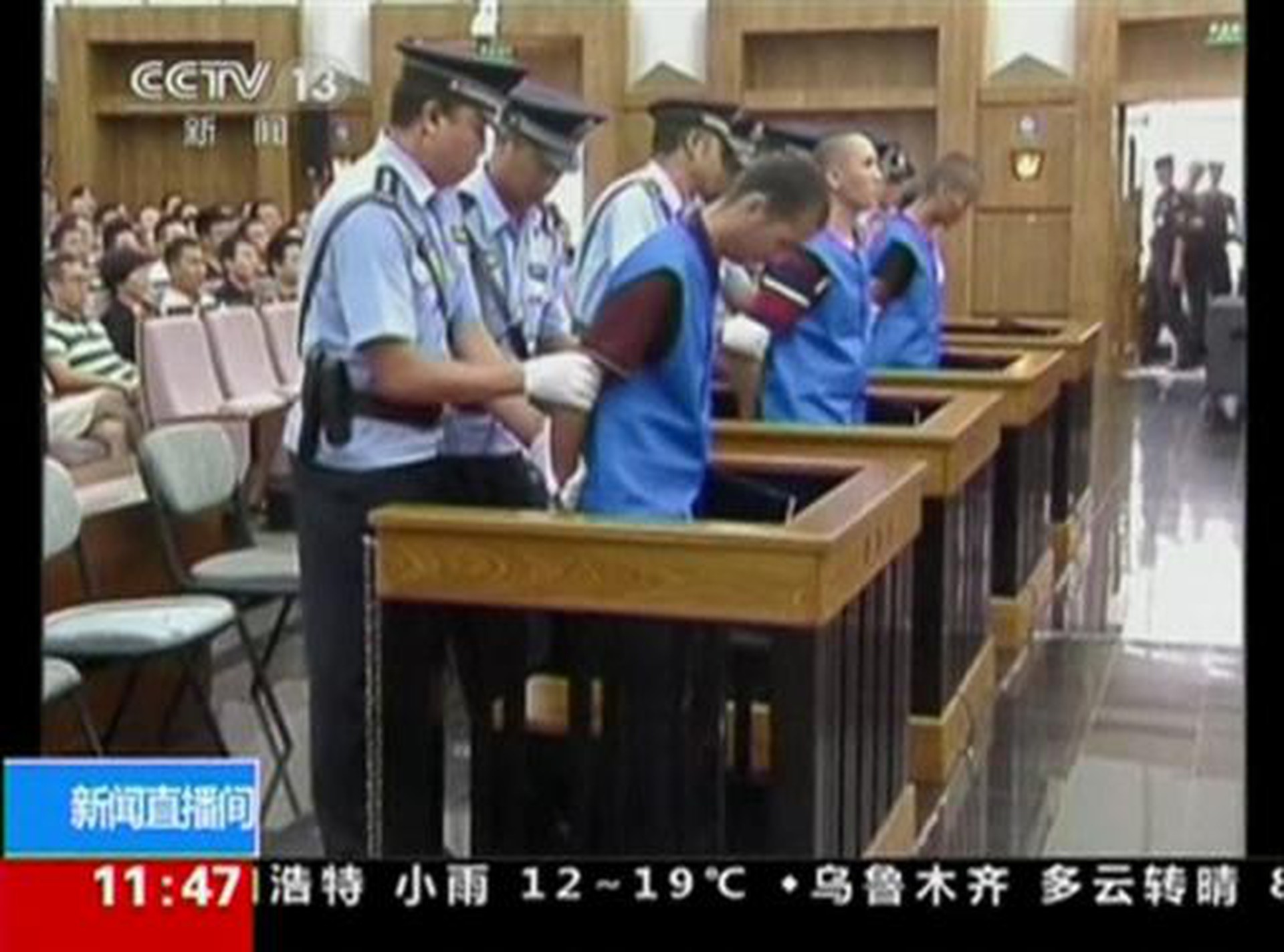 Defendants are escorted by police officers at a courtroom in Kunming City during the trial of four people accused of participating in an attack at a train station in southwestern China, in this still image taken from video September 12, 2014.   REUTERS-CCTV via Reuters TV