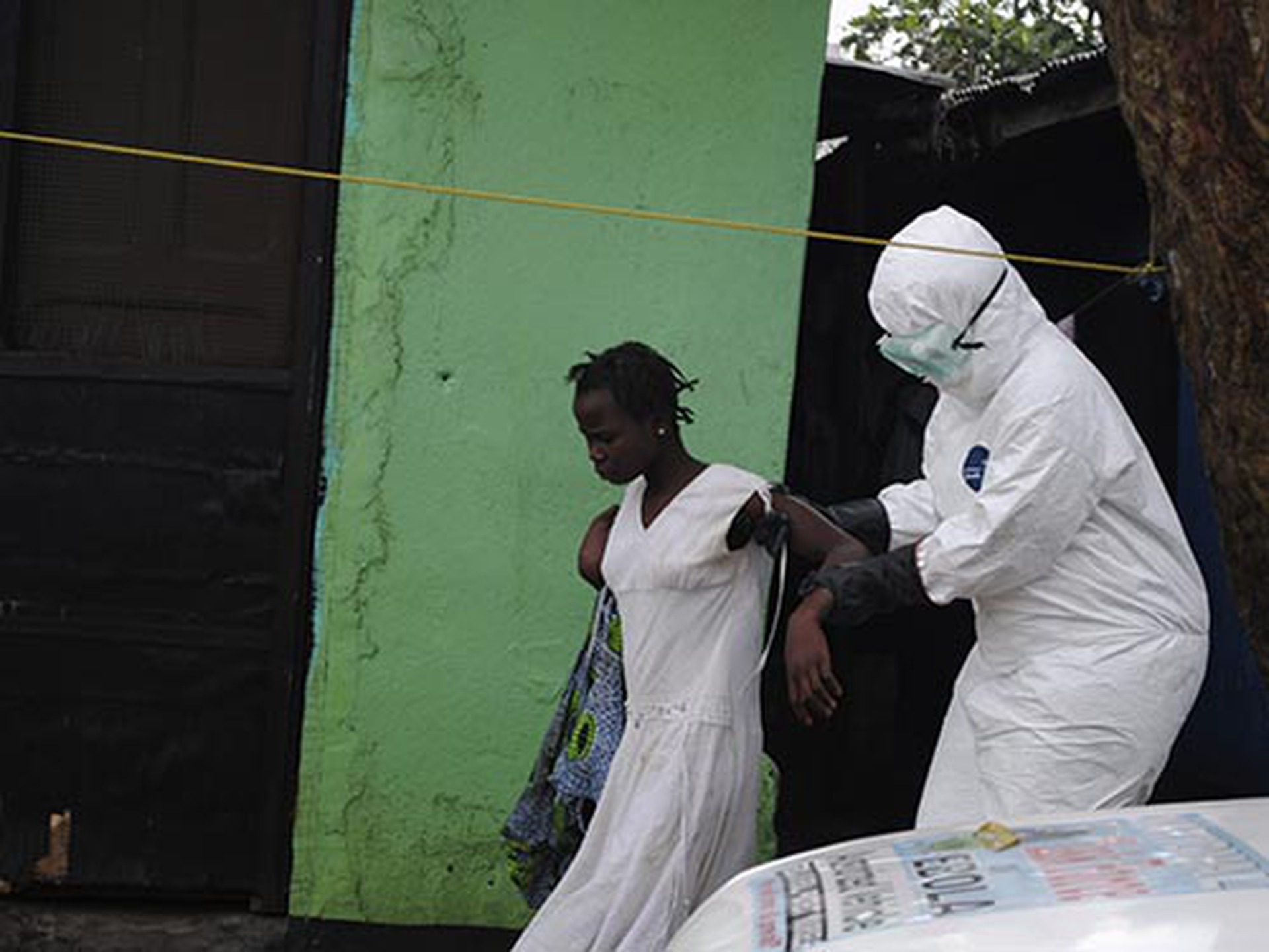 Nh&acirc;n vi&ecirc;n y tế đưa một phụ nữ nghi nhiễm virus Ebola tới xe cứu thương tại LiberiaẢnh: Reuters
