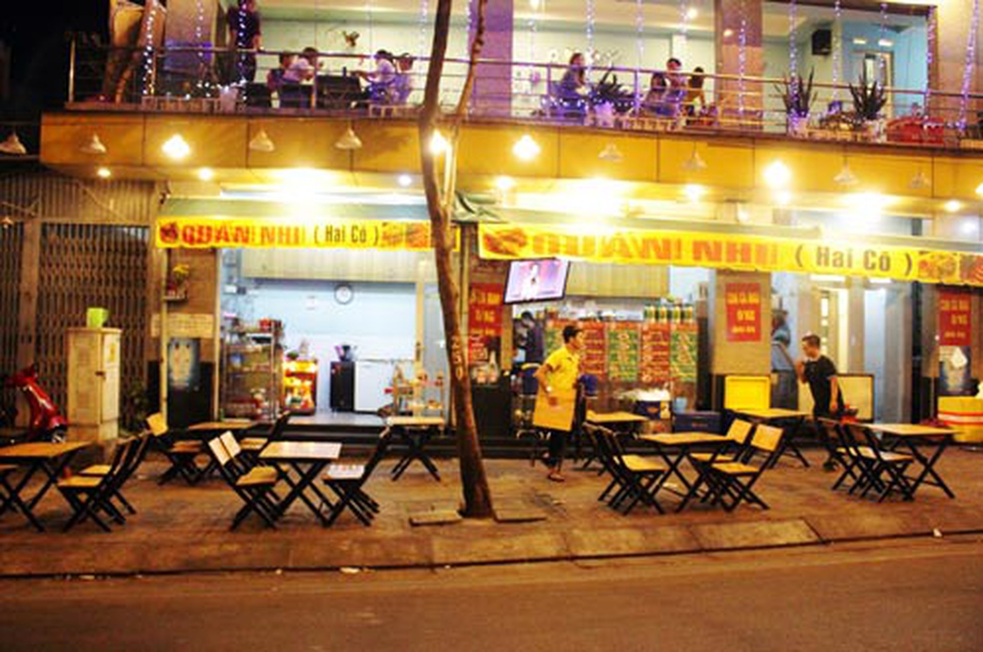 Chiều tối, nh&acirc;n vi&ecirc;n qu&aacute;n Nhi (Hai C&ocirc;) b&agrave;y b&agrave;n, ghế lấn chiếm vỉa h&egrave; đường Phạm Văn Đồng Ảnh: QUỐC CHIẾN