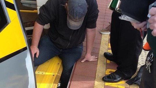 Người đàn ông bị mắc kẹt dưới đường ray xe lửa. Ảnh: Twitter