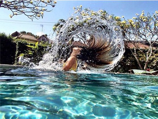 Women across Australia have started the bizzare trend, which sees them dipping their head in the water and quickly flicking their hair back behind them, creating a rainbow of water