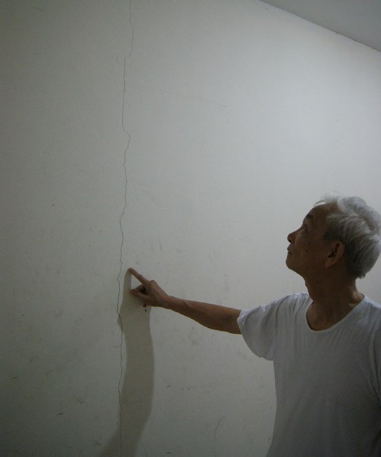 Ông Đào Mộc Mạc chỉ vết nứt trên tường ở tầng 1 nhà A1-D3 Đặng Xá. Ảnh: L.H.V.