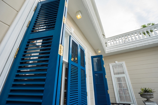 Màu xanh cô ban của các ô cửa nổi bật giữa nền sáng của ngôi nhà.