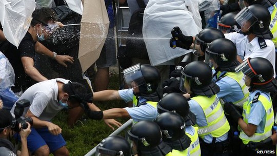 Cảnh sát xịt hơi cay vào người biểu tình. Ảnh: Reuters