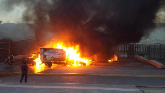 Nhiều xe tải bị đốt cháy trước tòa nhà chính phủ. Ảnh: RT