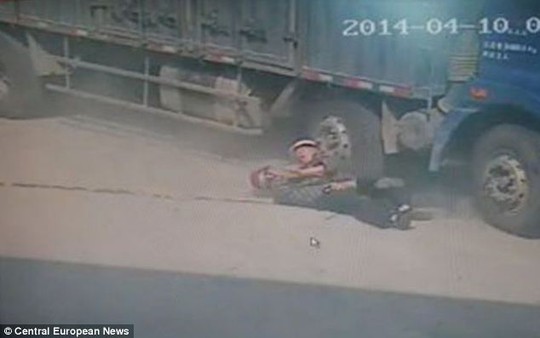 Hero father Hsiung Kuo, 71, pushes his son Yong, 47, to safety as he is dragged under the wheels of a lorry in Quanzhou in southeastern China
