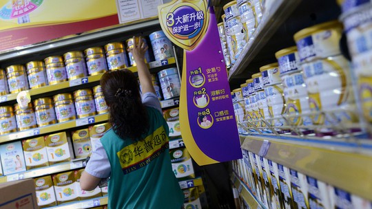 Một nhân viên đang kiểm tra hàng trong một siêu thị sữa bột ở Bắc Kinh