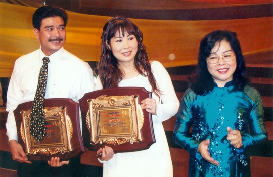 Bà Nguyễn Thị Hằng Nga - nguyên Tổng biên tập Báo Người Lao Động trao Giải Mai Vàng cho NSND Hồng Vân và NS Lê Tuấn Anh năm 2003.