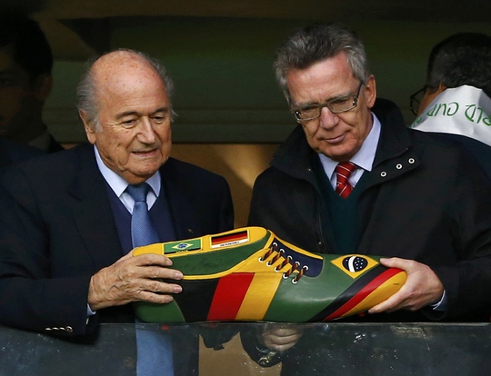Người đứng đầu FIFA cần giải trình trước báo giới về việc này. Trong ảnh: Ông Sepp Blatter và Bộ trưởng Nội vụ Đức Thomas de Maiziere trong trận Đức - Algeria ở vòng 1/6