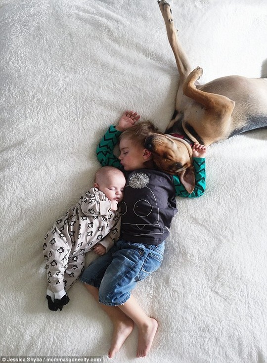 Cuddle: Beau seems to protect his younger sister as they lie on the blankets. Theo stretches out his leg