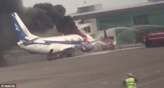 Destroyed: Dramatic footage shows 15ft-high flames erupting through a massive hole in the fuselage, sending thick, black smoke billowing across the airport as firefighters battle to control the blaze