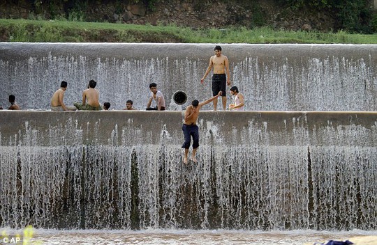 Desperate measures: Pakistani youths cool themselves off in a river on the outskirts of Islamabad. The electricity grid also crashed during the first days of the Muslim holy month of Ramadan