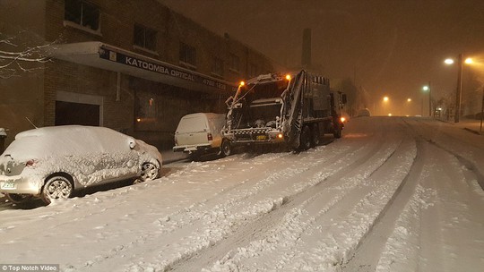 A garbage truck driver attempts to fulfill his early morning duties after roads were blanketed in white powder