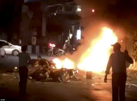Inferno: Flames burn after the explosion in central Bangkok which is thought to have killed at least 27 people, including four foreigners