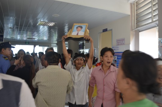 Người thân anh Sang cầm di ảnh anh đòi gặp bác sĩ Đoàn Văn Hùng.