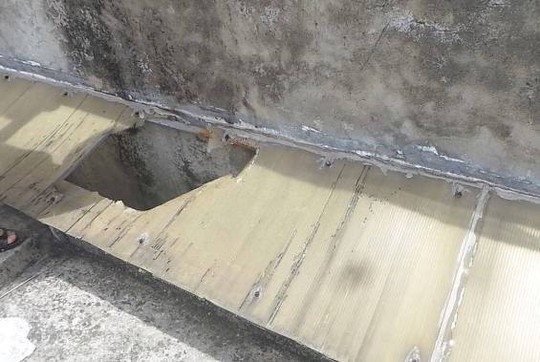 Miếng nhựa bà dẫm phải và bị rơi xuống khe giữa hai toà nhà