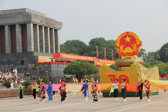 Dẫn đầu đoàn diễu hành là Quốc huy nước Cộng hòa xã hội chủ nghĩa Việt Nam